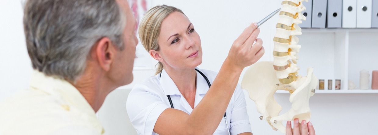 Dokter wijst naar ruggenwervel