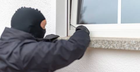 Man met bivakmuts op probeert met een schroevendraaier in te breken via een raam